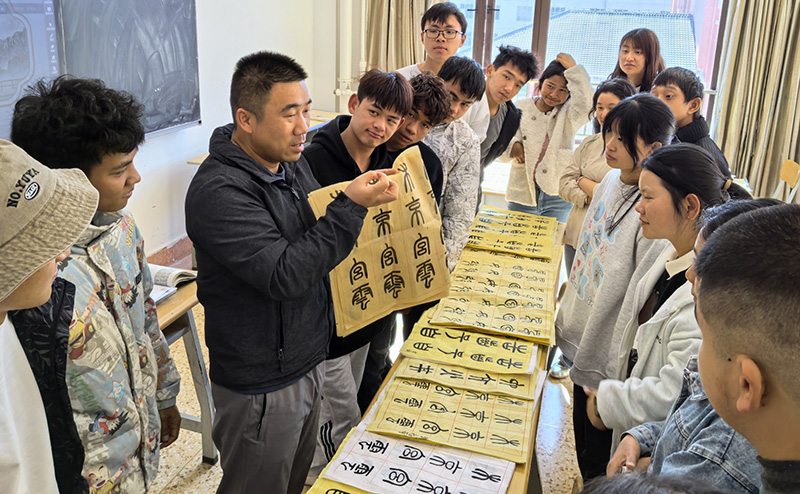 徐润刚用手语为学生们讲解书法篆刻。ac米兰官网中文网站供图